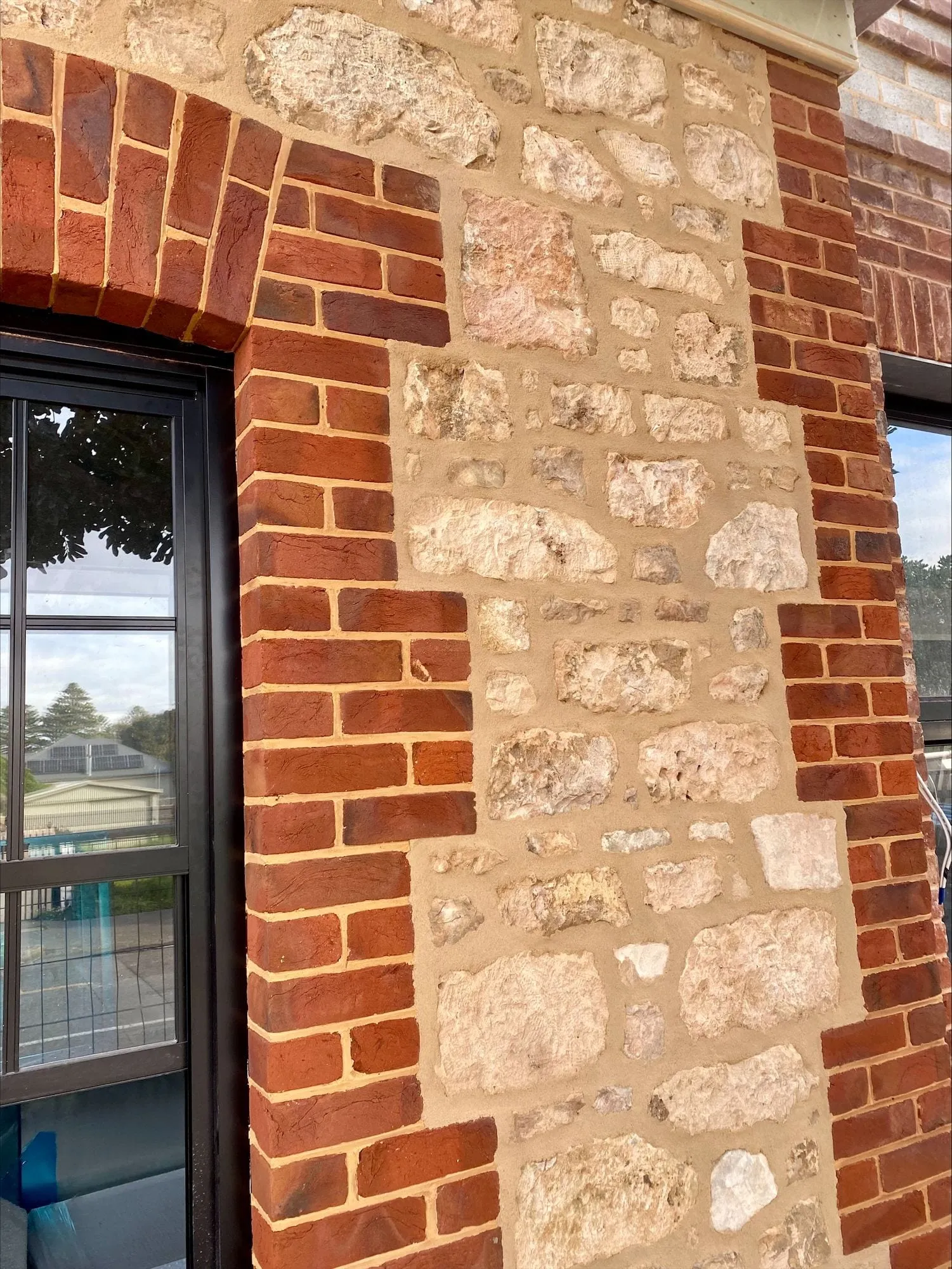 Brick quoins and a brick arch set into a stone wall