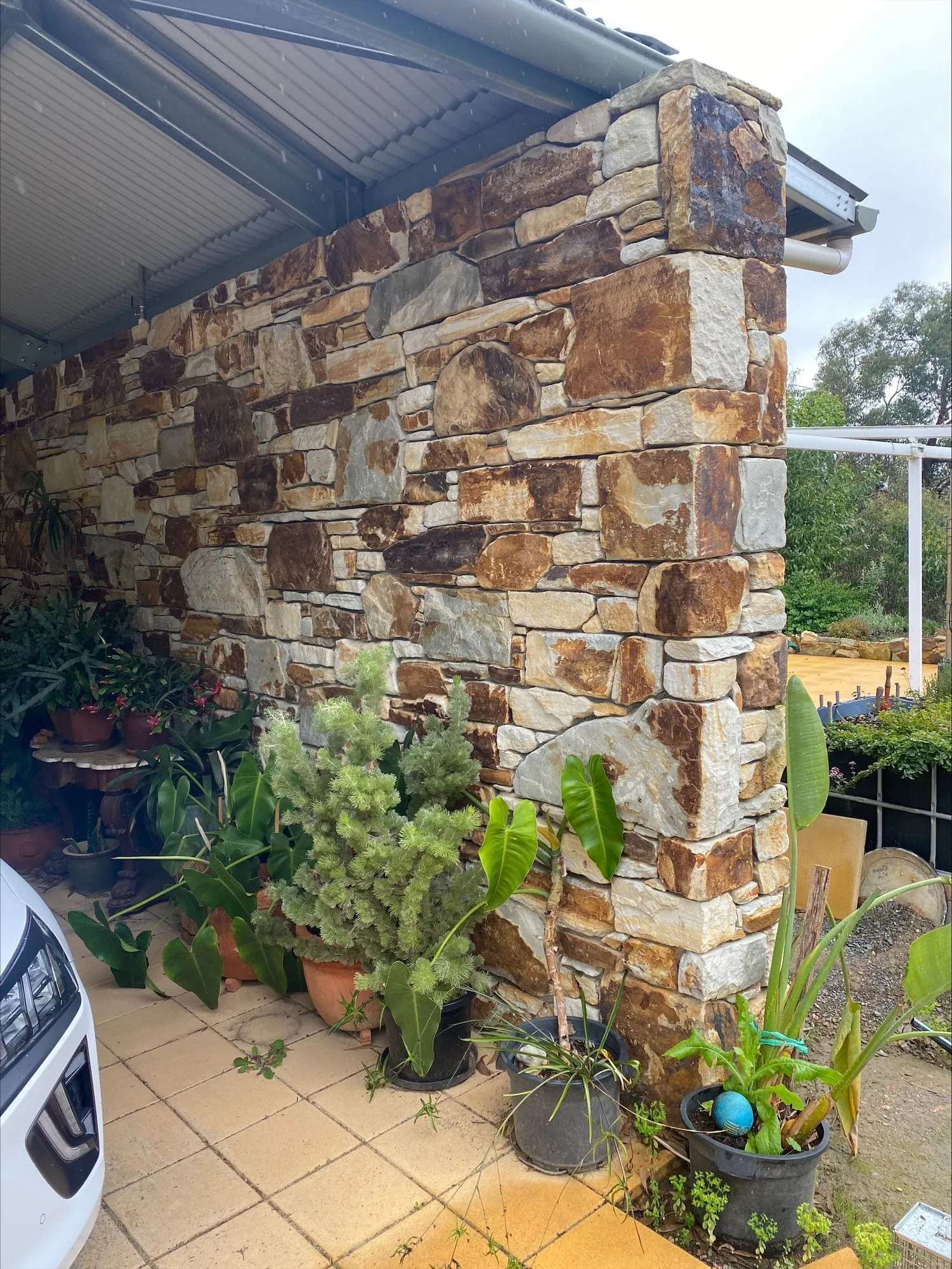 A stone feature wall softened by garden plants