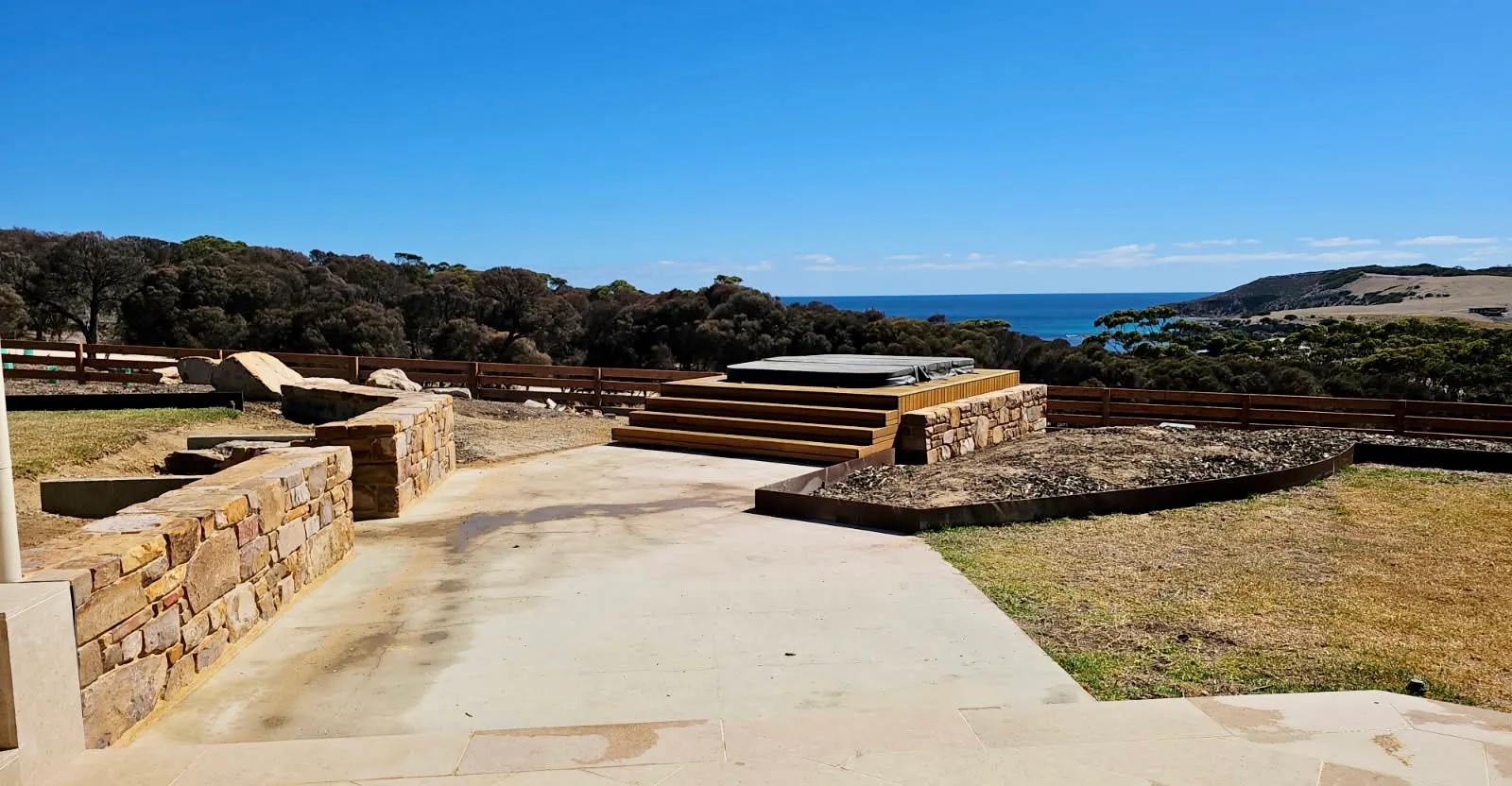 A stone terraced lookout and paving above the coast